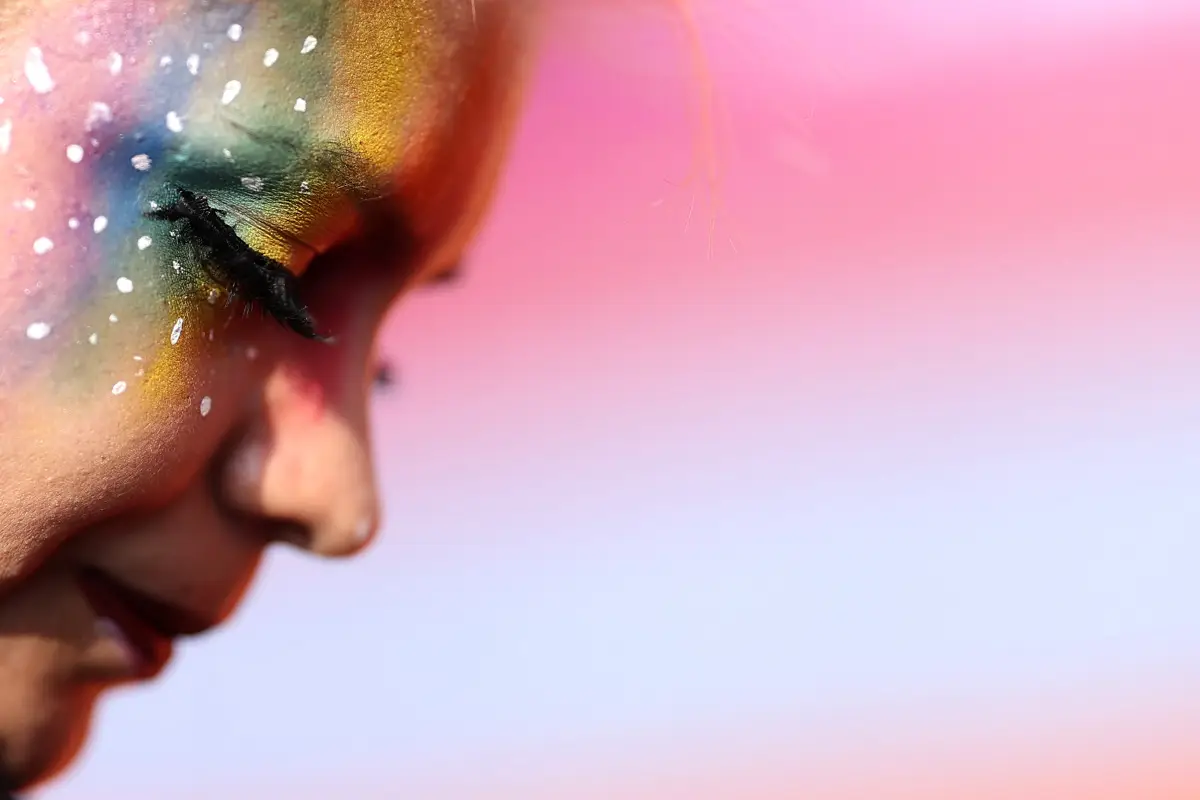 (Un asistente a la marcha del orgullo LGBT, muestra un maquillaje con los colores del arcoíris​​)