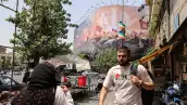 Los iraníes pasan junto a una valla publicitaria antiestadounidense en la plaza Enghelab, en el centro de Teherán, el 3 de agosto de 2026. Irán negó que se estuvieran llevando a cabo negociaciones con los Estados Unidos después de que el presidente de los Estados Unidos dijera que las nuevas conversaciones comenzarían el 3 de agosto en un esfuerzo por poner fin a su guerra, ahora en su sexto mes.