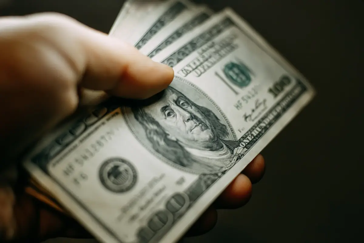 Man hand with a stack of hundred US dollars bills, close up