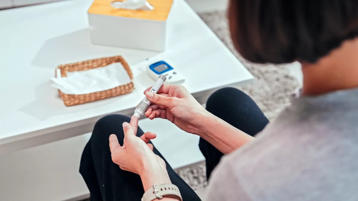 Young adult Woman doing a glucose blood test at home