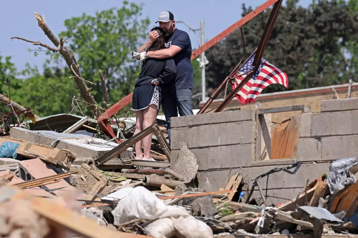 Phillip y Kimberly Ergish se abrazan mientras miran los restos de su casa el día después de que un tornado mortal golpeara Greenfield, Iowa, EE. UU., el 22 de mayo de 2024.