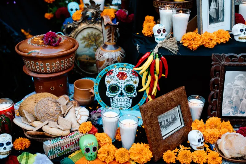 Ofrenda de muertos con calaveras, fotografías y flor de cempasúchil.