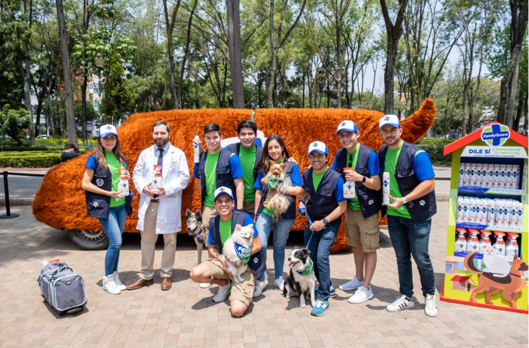 Los promotores de FamilyGuard, el veterinario y algunos perros posan para la foto con los productos de limpieza y desinfección.