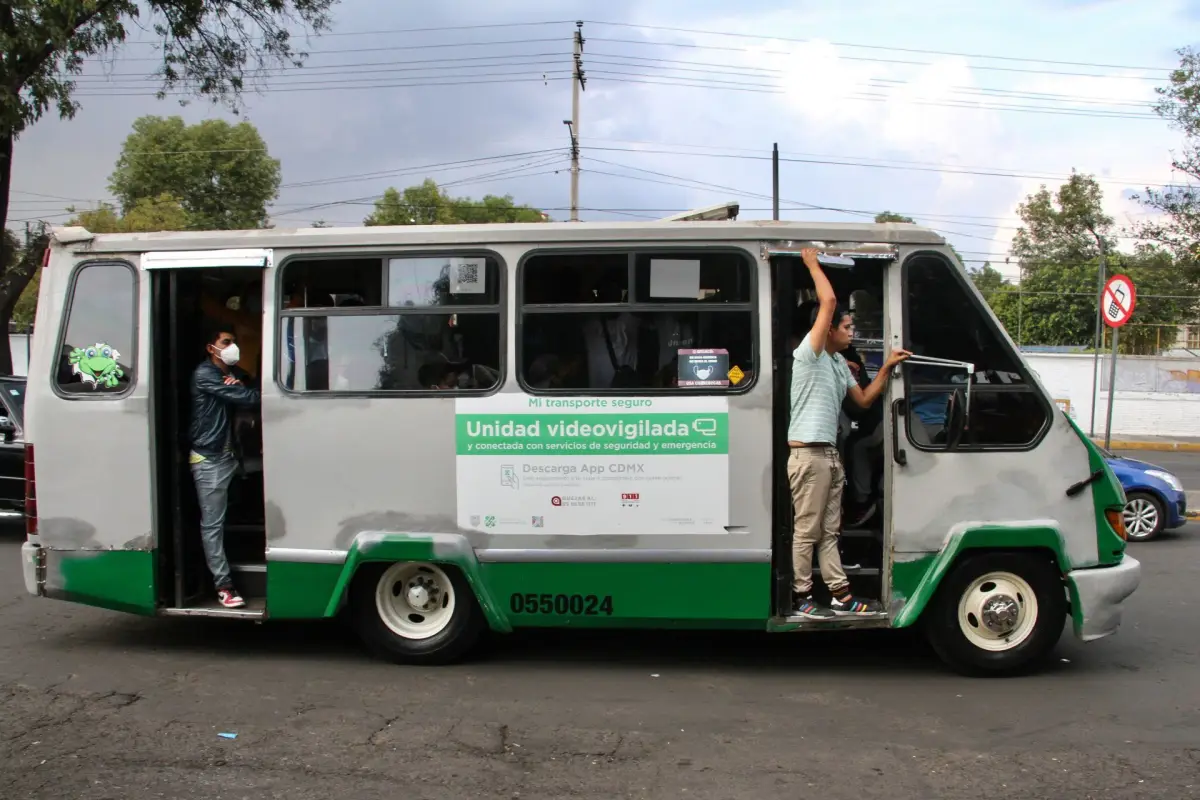 El gobierno de CDMX anunció que sube la tarifa del transporte público. (Microbús transita con personas afuera en ambas puertas por la alcaldía Xochimilco).