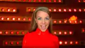 Foto de una escena del video "Oops!... I did it again" de Britney Spears, con la cantante en medium shot vestida de rojo.