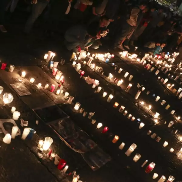 Frente a Bellas Artes, personas encienden velas