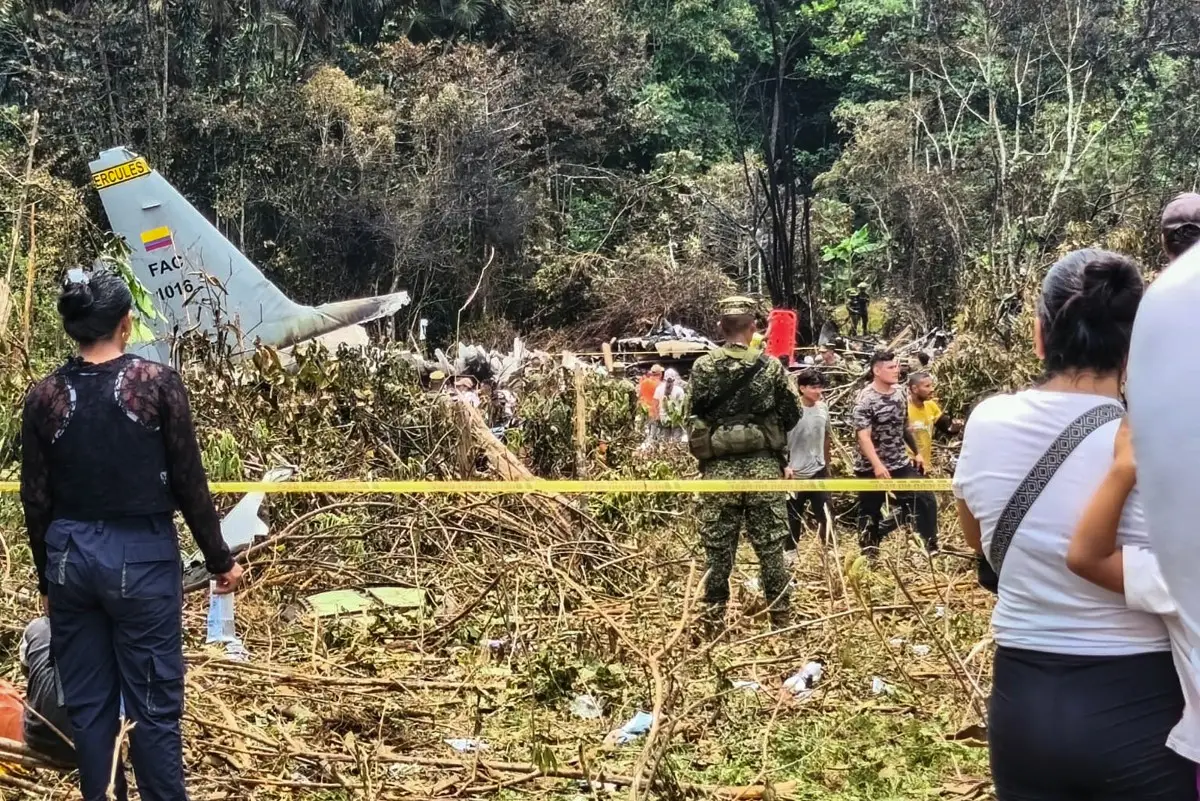 Personas y soldados se encuentran cerca de los escombros de un Hércules de la Fuerza Aérea que se estrelló durante el despegue, en Puerto Leguizamo, Colombia, cerca de la frontera sur con Ecuador, el 23 de marzo de 2026.