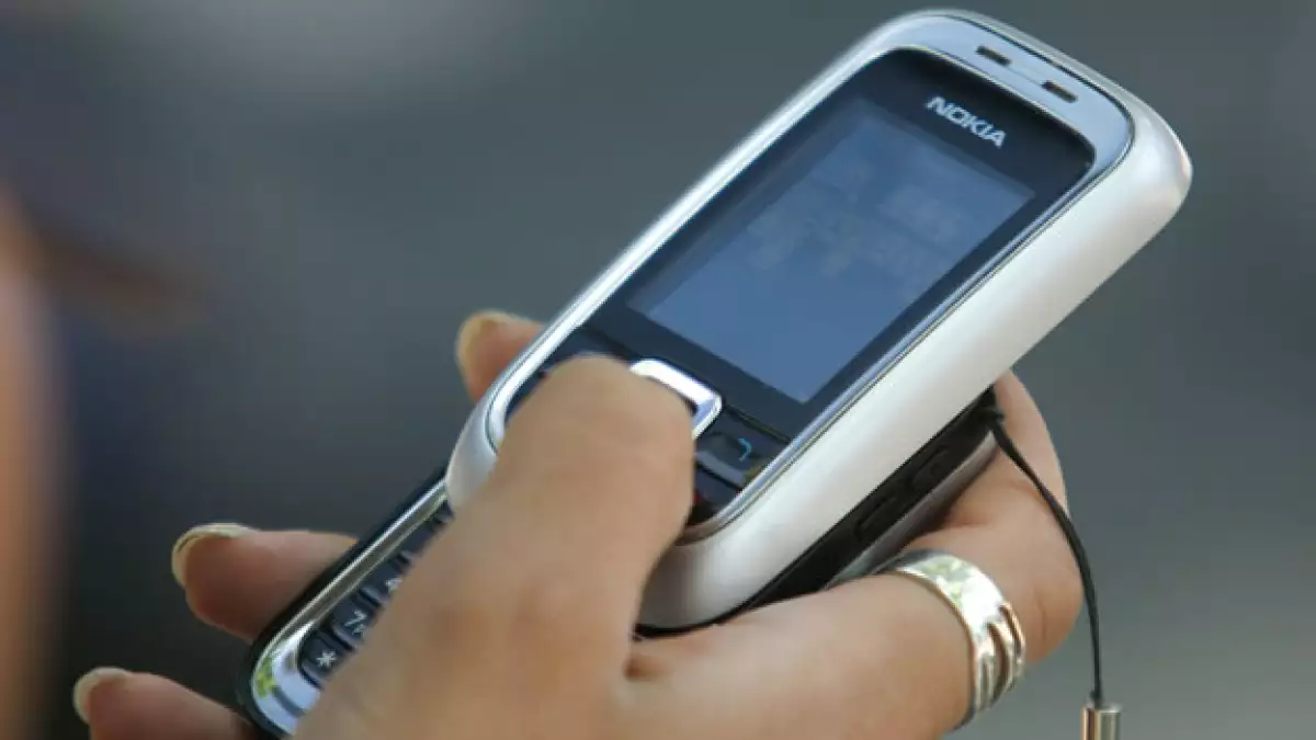 Una mujer sostiene un celular en la mano