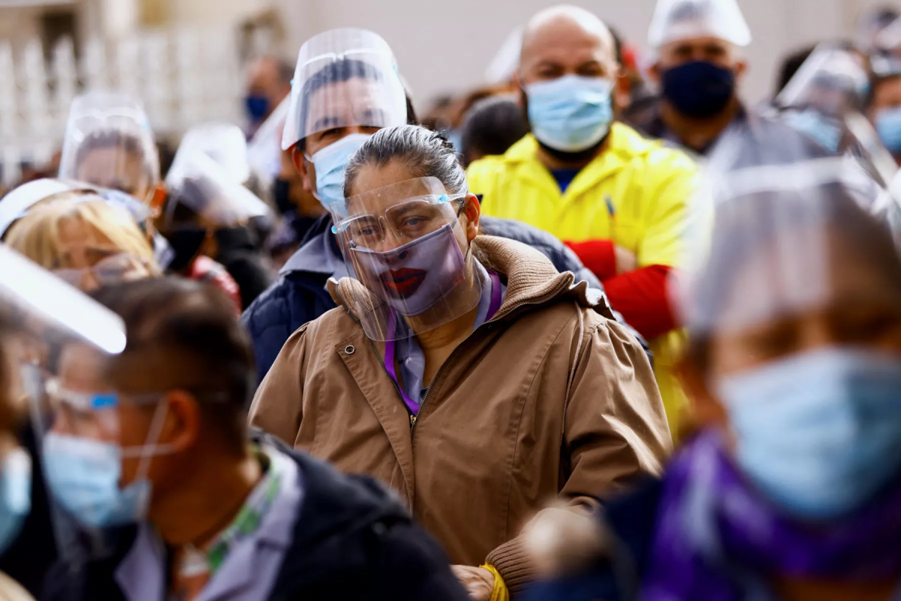 (Un grupo de trabajadores hacen fila para hacerse la prueba Covid)