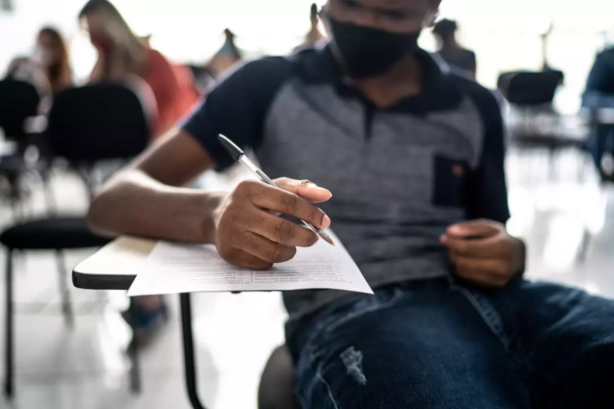 Así se pueden consultar las calificaciones de secundaria en CDMX. (Estudiante sentado en una butaca en salón de clases). 