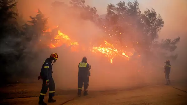 Bomberos luchan contra un incendio forestal en Ntrafi, Atenas, Grecia. 