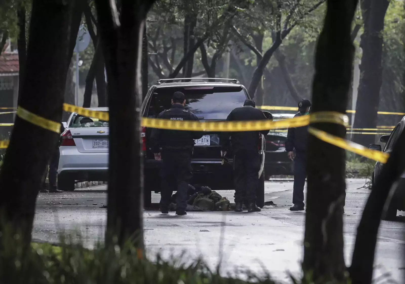 Police officers are seen near a vehicle after a shooting in Mexico City