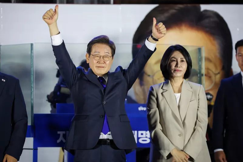 Lee Jae-myung, el candidato presidencial del Partido Demócrata de Corea del Sur, hace gestos mientras está de pie junto a su esposa Kim Hye-kyung, mientras saluda a sus partidarios frente a la Asamblea Nacional en Seúl, Corea del Sur, el 4 de junio de 2025.