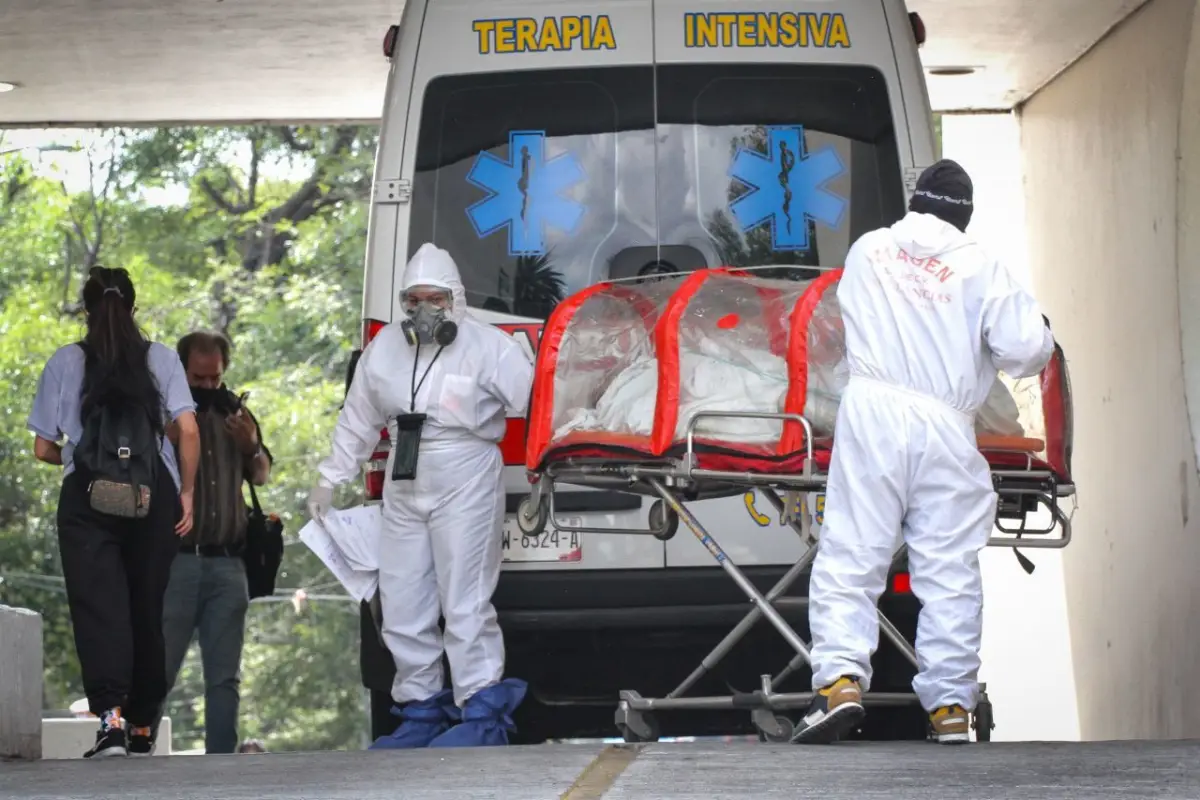 Paramédicos ingresan a una persona encapsulada al área de urgencias por COVID-19.