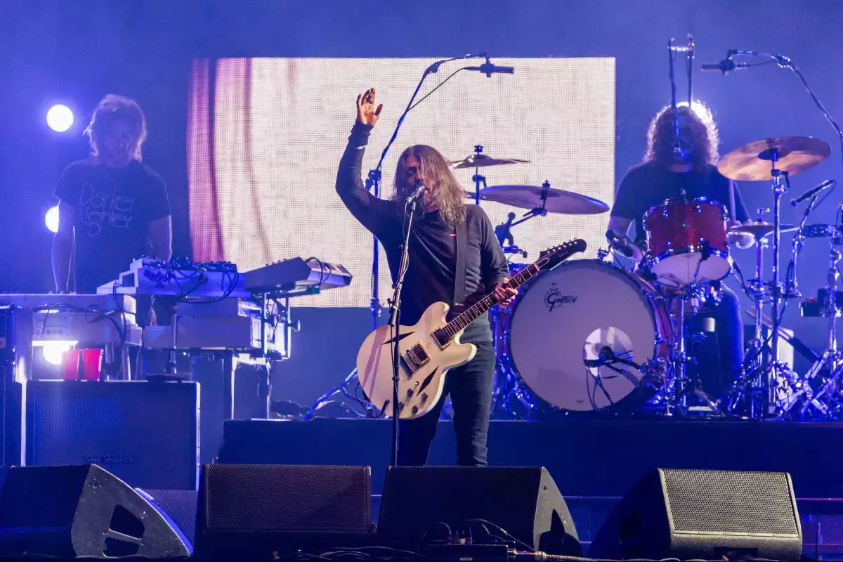 Foto de Dave Grohl con guitarra en mano frente al micrófono cantando en una presentación de los Foo Fighters