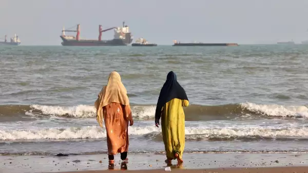 Los iraníes disfrutan de la orilla del mar mientras se ven barcos en el Estrecho de Ormuz frente a Bandar Abbas, en el sur de Irán, el 10 de agosto de 2026.