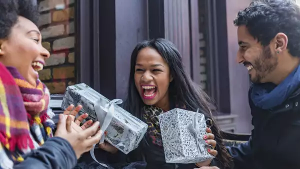 Excited Young Friends Exchanging Christmas Gifts