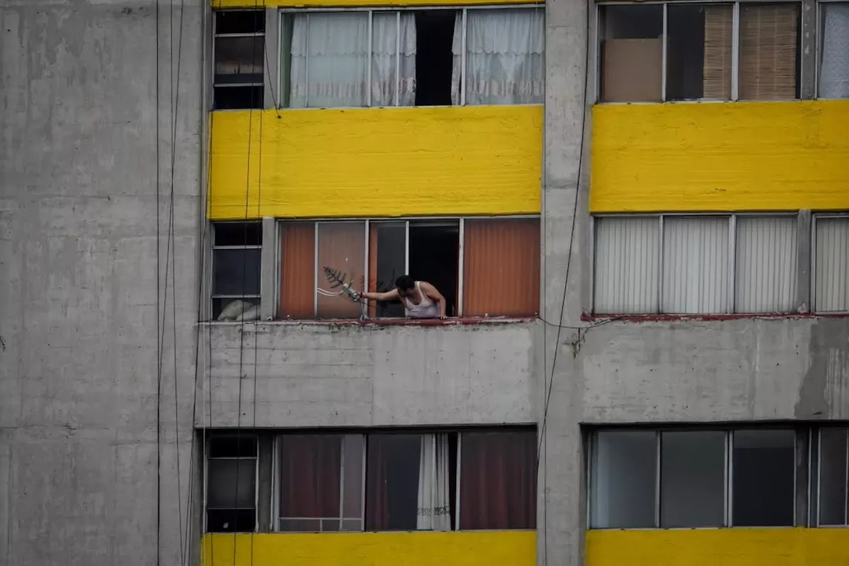 Un hombre repara una antena de televisión en un edificio del Conjunto Urbano Nonoalco Tlatelolco, en el marco de la cuarentena y emergencia sanitaria.