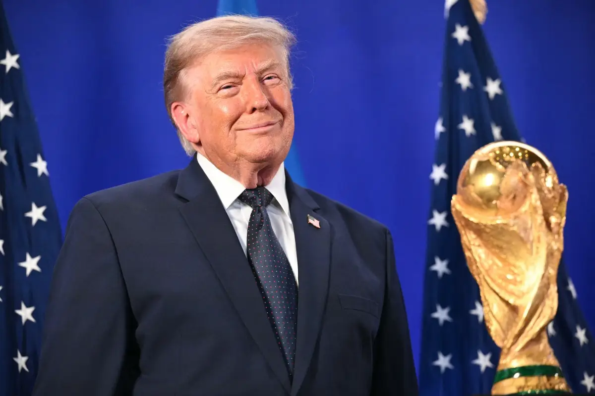 El presidente de los Estados Unidos, Donald Trump, se encuentra junto al Trofeo de la Copa Mundial de la FIFA mientras escucha al presidente de la FIFA, Gianni Infantino (fuera del marco), hablar durante una recepción de la FIFA en la Torre Trump en Nueva York el 17 de julio de 2026. El presidente Trump asistirá a la final de la Copa del Mundo de 2026 entre España y Argentina.