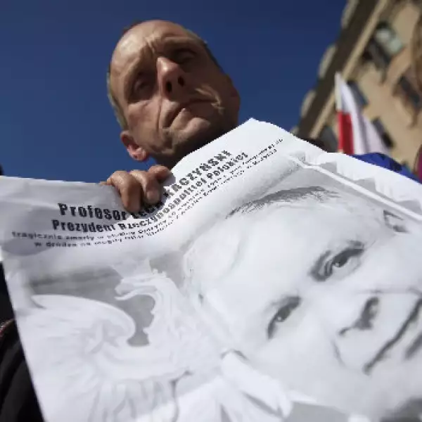 Un hombre sostiene un poster