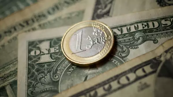 moneda de un euro sobre billete de un dolar