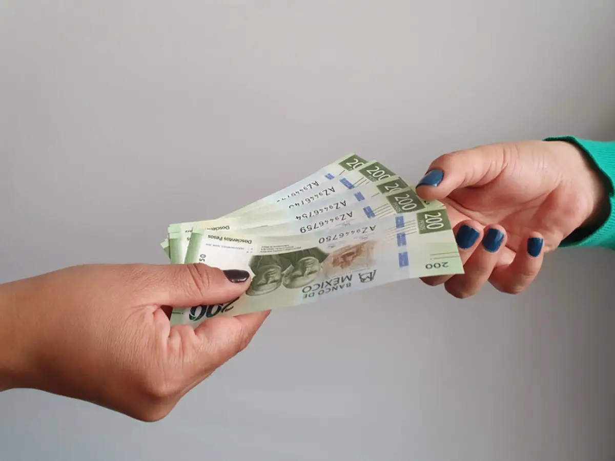 women hands paying and receiving mexican money