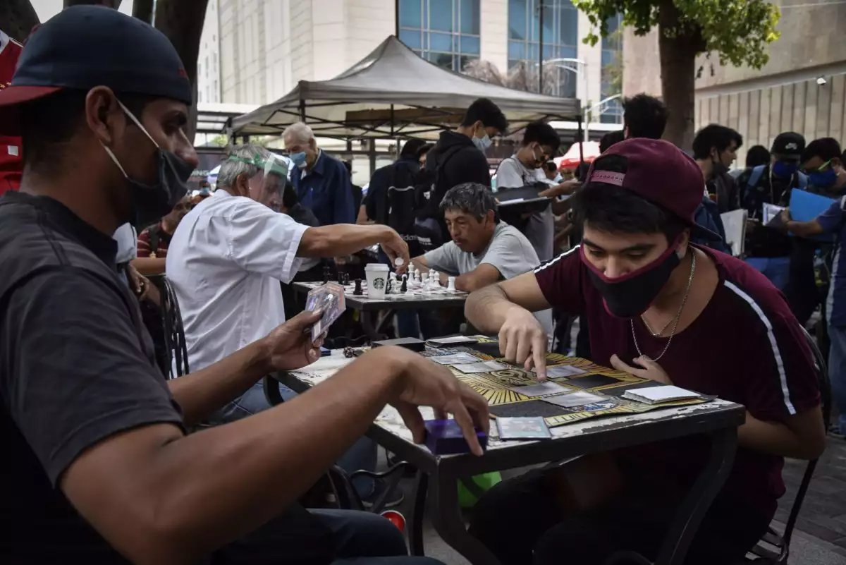 Decenas de personas se reunieron en la Plaza de la Solidaridad para intercambiar y jugar cartas de colección mientras continúa activo el semáforo naranja epidemiológico por Covid-19 en la capital del país.