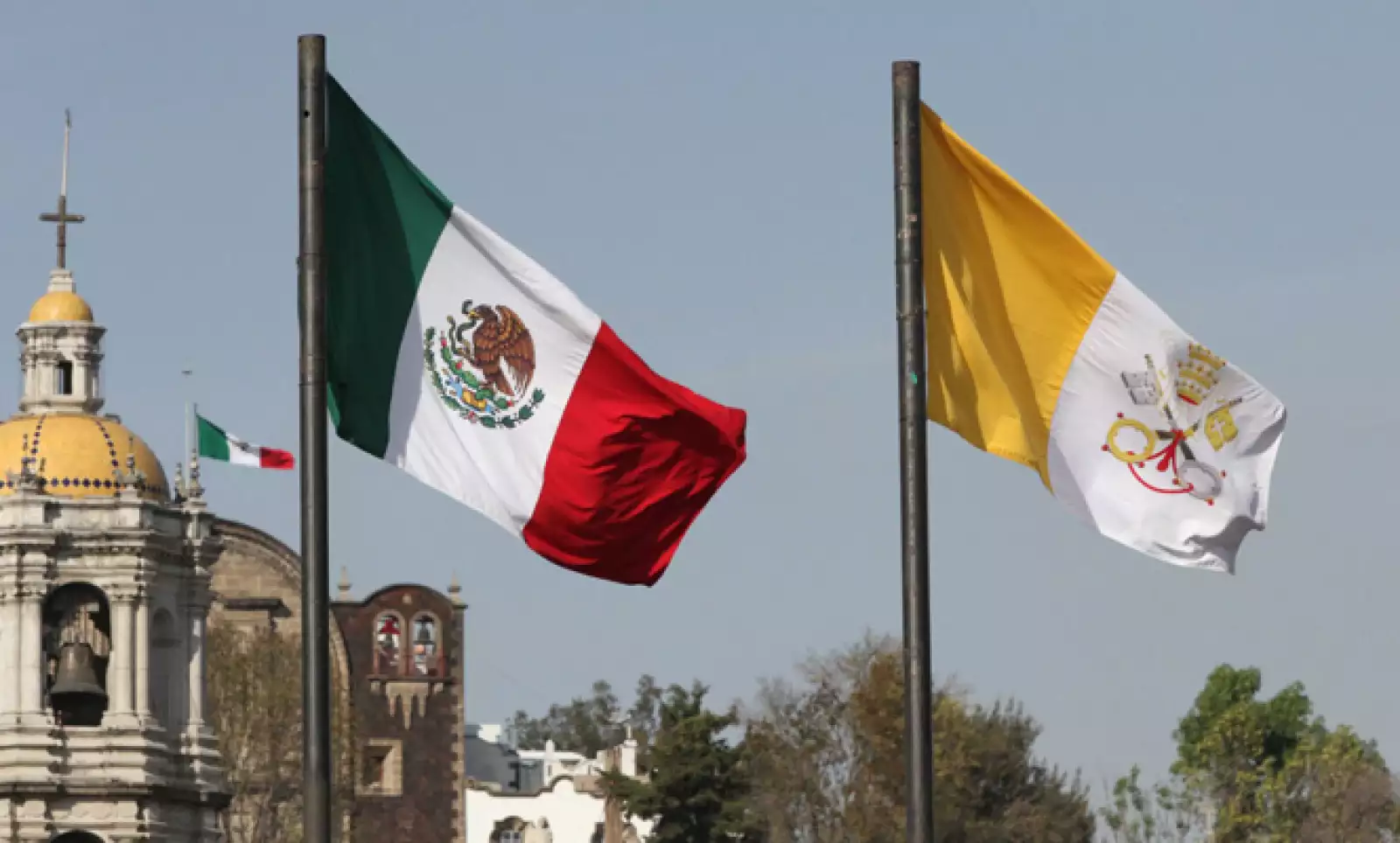 Afuera del recinto ondean las banderas de ambas naciones.