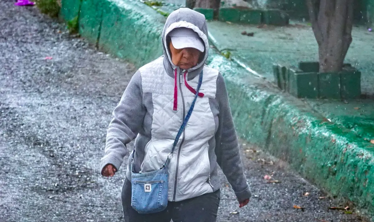 Mujer camina a pesar de bajas temperaturas.