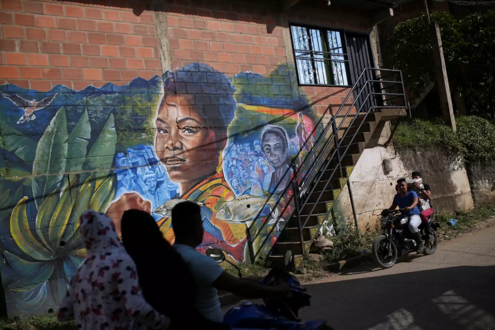 Motociclistas pasan frente a un mural que representa a la candidata de izquierda a la vicepresidencia colombiana, Francia Márquez, en Suárez, Colombia.