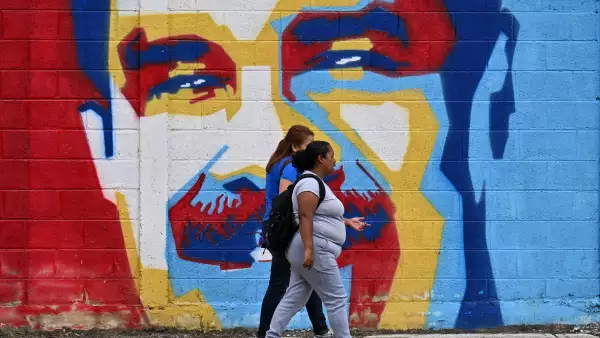Mujeres caminan frente a un mural del derrocado presidente venezolano Nicolás Maduro en Caracas el 10 de enero de 2026.