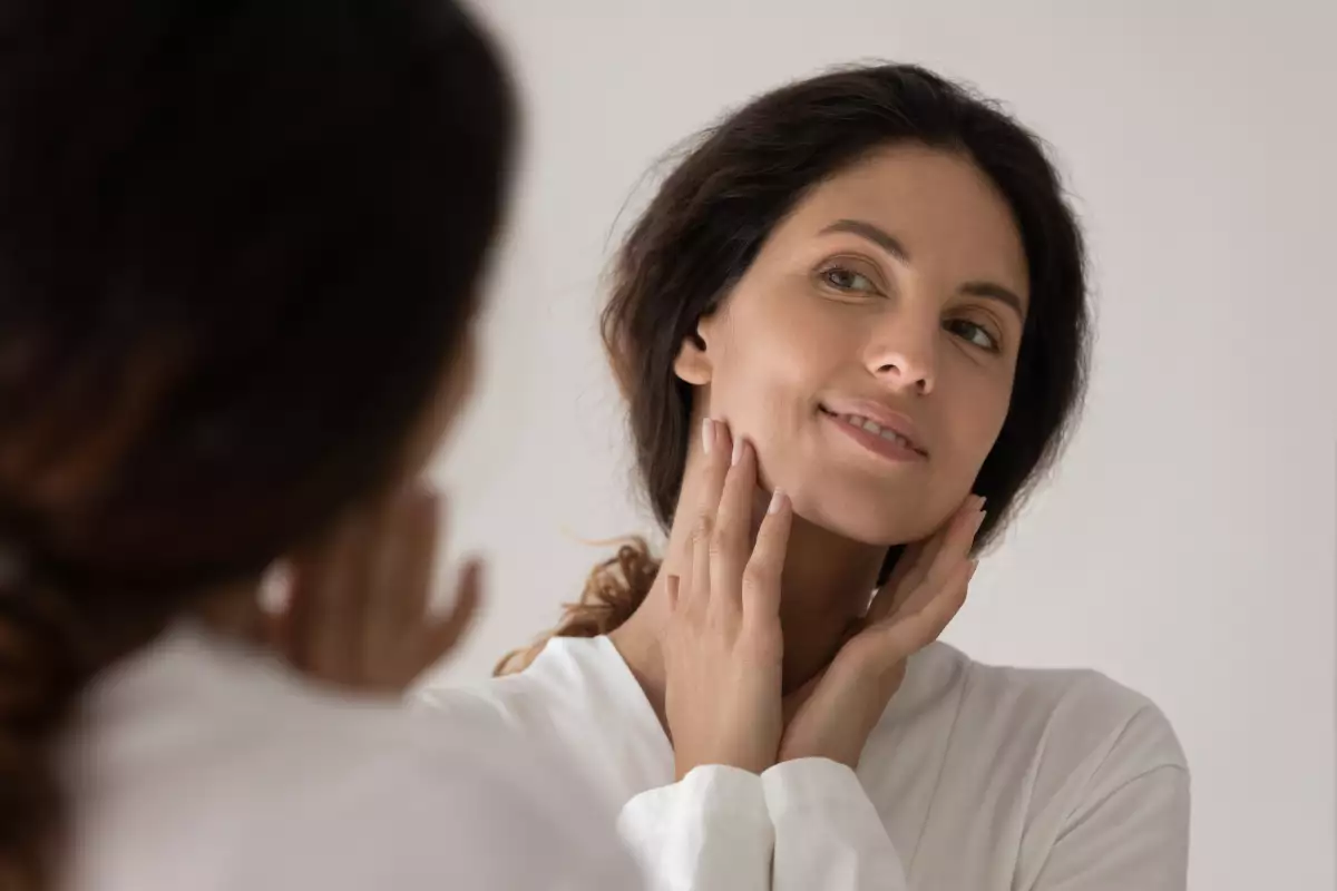 Close,Up,Happy,Beautiful,Woman,Touching,Face,,Looking,In,Mirror,