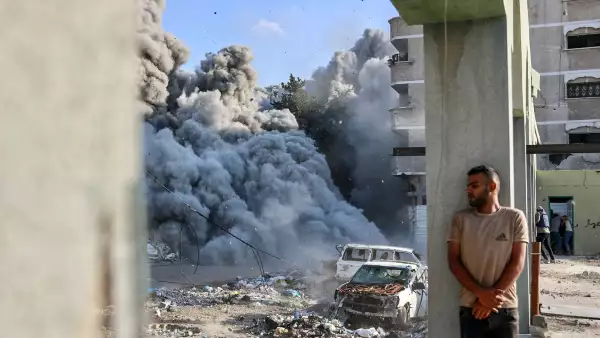 Un hombre se cubre detrás de una columna mientras una explosión propaga humo y polvo durante un ataque israelí que supuestamente tuvo como objetivo una escuela en el distrito de Zeitoun en las afueras de la ciudad de Gaza, el 1 de septiembre de 2024, en medio del conflicto en curso entre Israel y el grupo palestino Hamas.