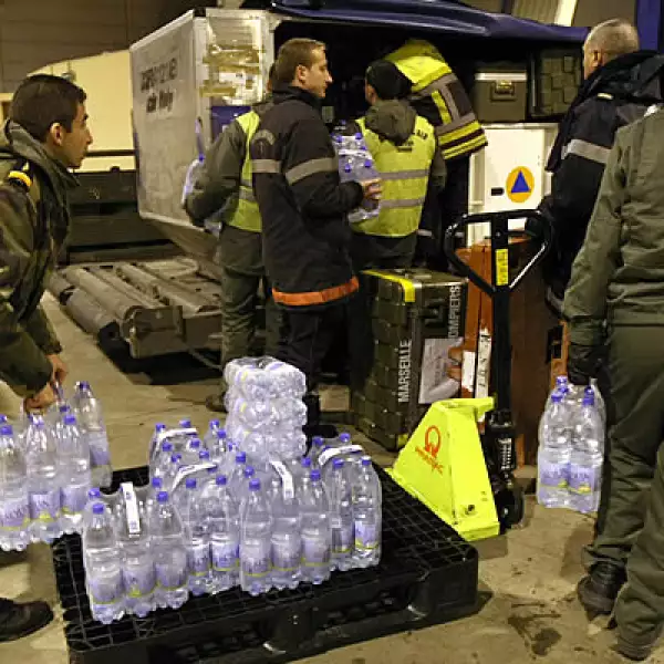 Miles de toneladas de comida, agua y medicamentos han empezado a llegar al aeropuerto de la ciudad de Puerto Principe. En la foto, bomberos franceses se alistan para ayudar descargando agua y otros alimentos.