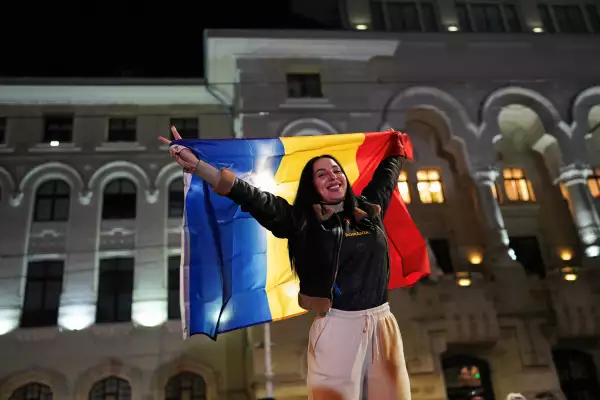 Una partidaria de la candidata presidencial Nicusor Dan sostiene una bandera rumana, mientras reacciona después de las encuestas a pie de urna en la segunda vuelta de las elecciones presidenciales de Rumania, en Bucarest, Rumania, el 18 de mayo de 2025.