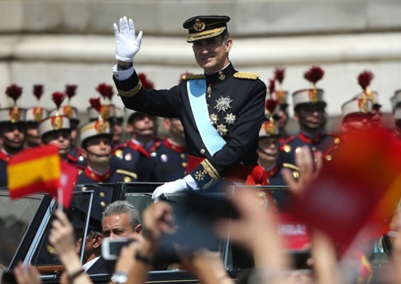Desde un descapotable, Felipe VI saluda a la multitud que lo esperaba en las calles de Madrid.