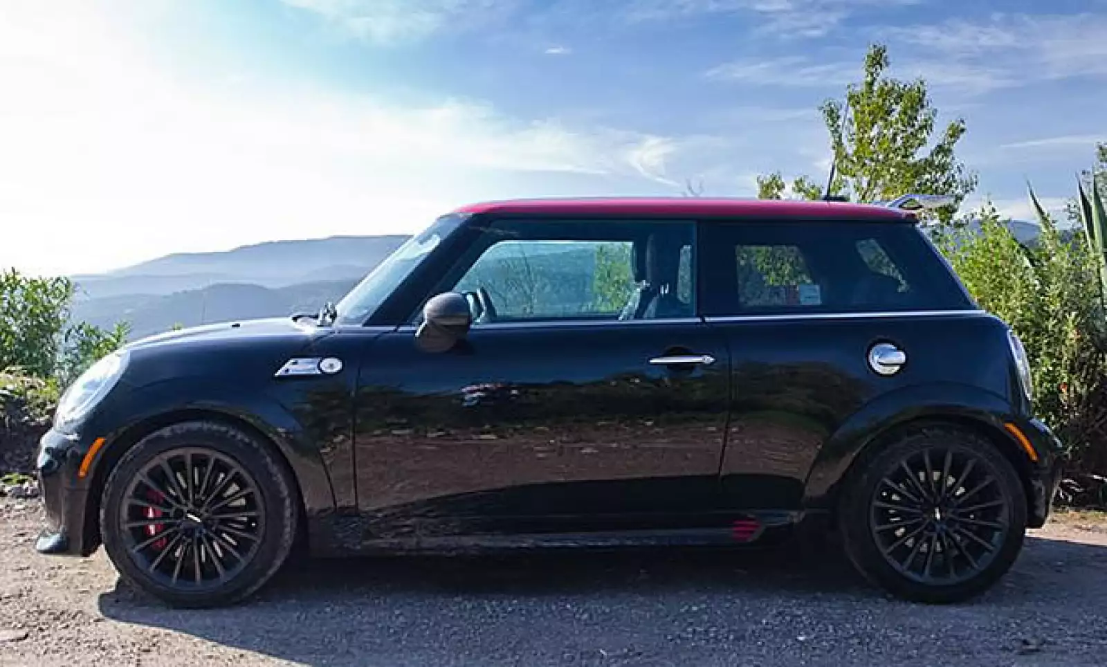 El toldo del vehículo es rojo y causa un efecto contrastante con el negro del resto de la carrocería.