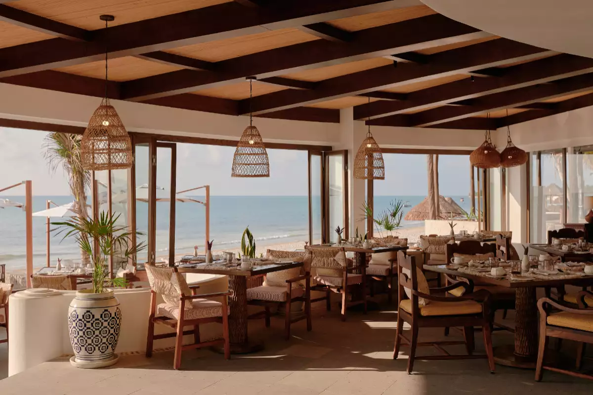 Foto general del restaurante del hotel Zadún en Los Cabos con vista al mar por las ventanas abiertas.