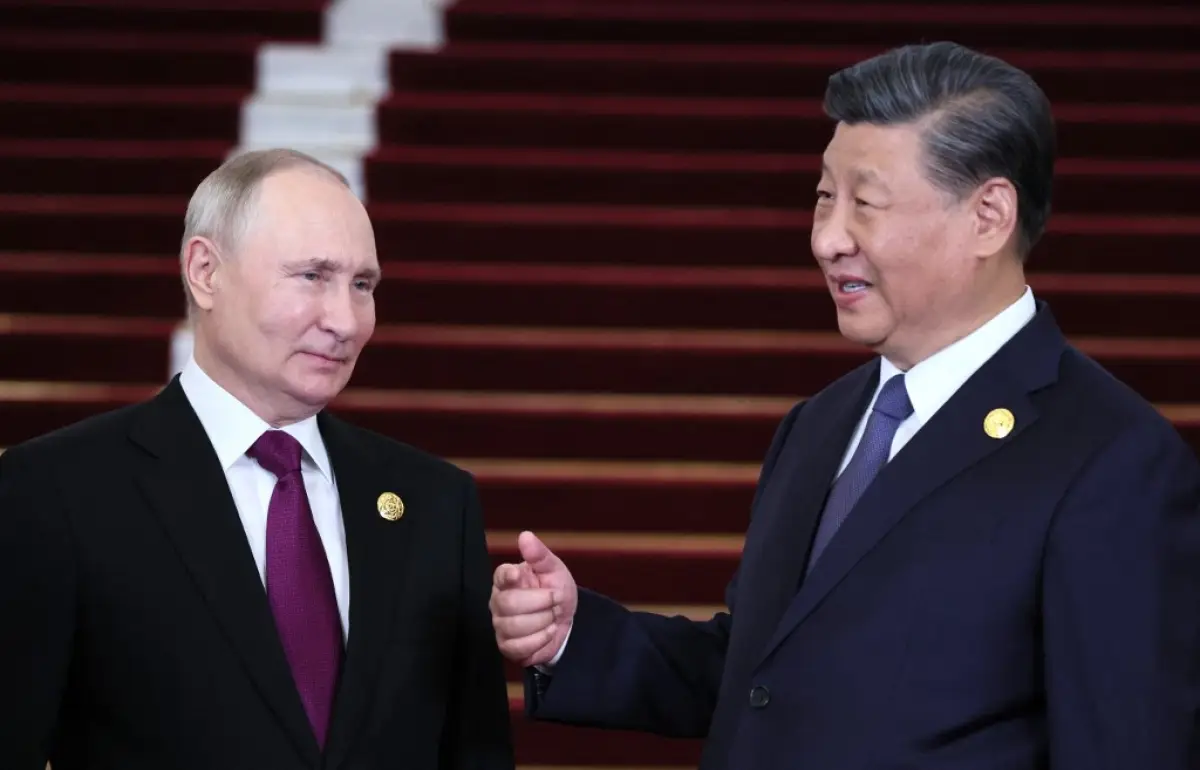Esta fotografía de la piscina distribuida por la agencia estatal rusa Sputnik muestra al presidente de Rusia, Vladimir Putin, y al presidente chino Xi Jinping interactuando durante una ceremonia de bienvenida en el Tercer Foro del Cinturón y la Ruta en Beijing el 17 de octubre de 2023.