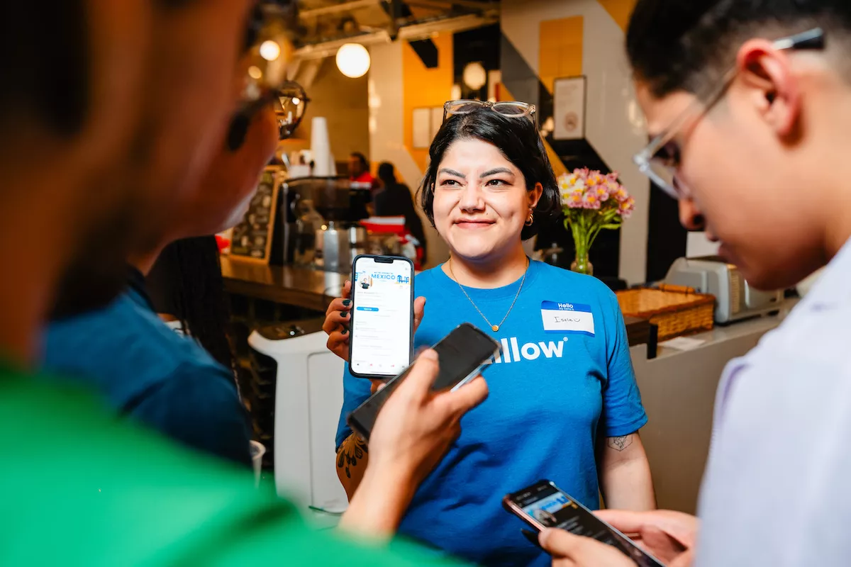 Imagen de varias personas reunidas revisando el sitio de Zillow a través de sus celulares.