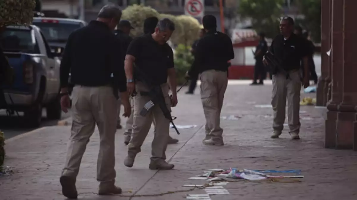 Elementos de seguridad inspeccionan el lugar donde murieron varias personas en un enfrentamiento con fuerzas federales