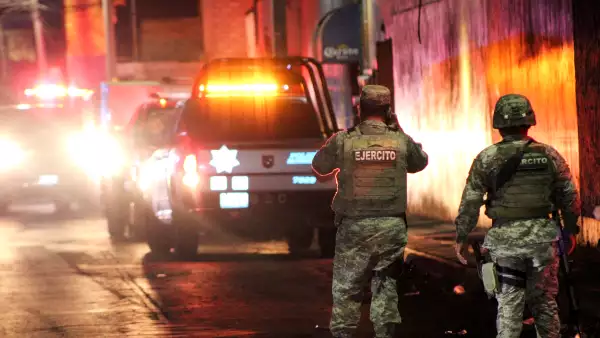 (Un soldado toma una foto con su teléfono en la escena donde hombres armados abrieron fuego en dos bares, matando al menos a 10 personas, en Celaya, México, el 23 de mayo de 2022)