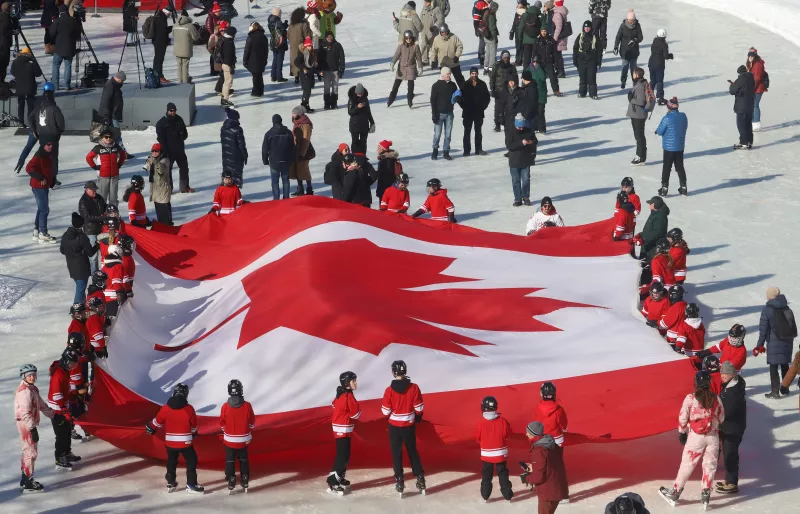 Los patinadores sostienen una gran bandera canadiense en una ceremonia del Día de la Bandera Nacional de Canadá, un día antes de la celebración oficial del Día de la Bandera, en el Rideau Canal Skateway en Ottawa, Ontario, Canadá, el 14 de febrero de 2025.