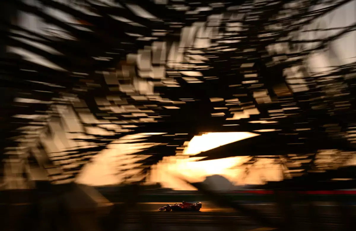 Foto del auto de Lecrerc conduciendo un Ferrari con el atardecer de Bahrein detrás.