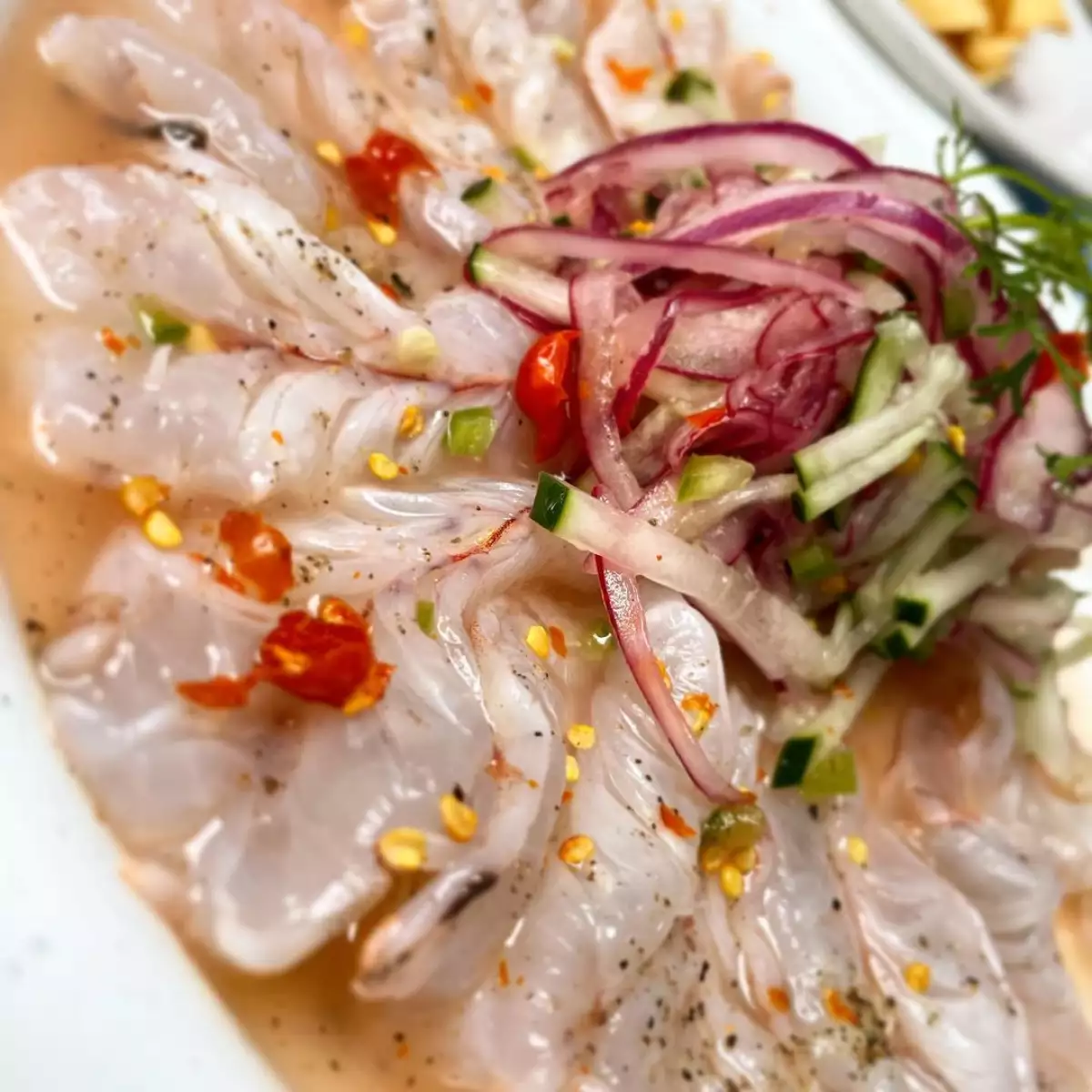 Foto de una tostada de aguachile de camarón con chile chiltepín y jugo de limón.