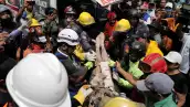 Los rescatistas llevan a una persona después de ser sacado vivo de los escombros de un edificio derrumbado en Caraballeda, estado de La Guaira, Venezuela, el 28 de junio de 2026, después de terremotos.