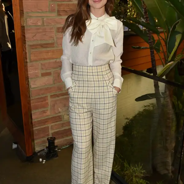 Conquistó el look oficinista con pantalones de cuadros Houghton Fall 2015 y blusa con moño de Kate Spade. Le dio un toque especial con pumps rojos de ante Paul Andrew.