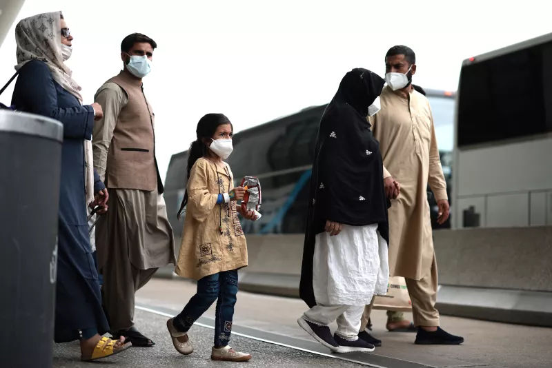 Los refugiados caminan para abordar un autobús en el aeropuerto internacional de Dulles después de ser evacuados de Kabul tras la toma de Afganistán por los talibanes.