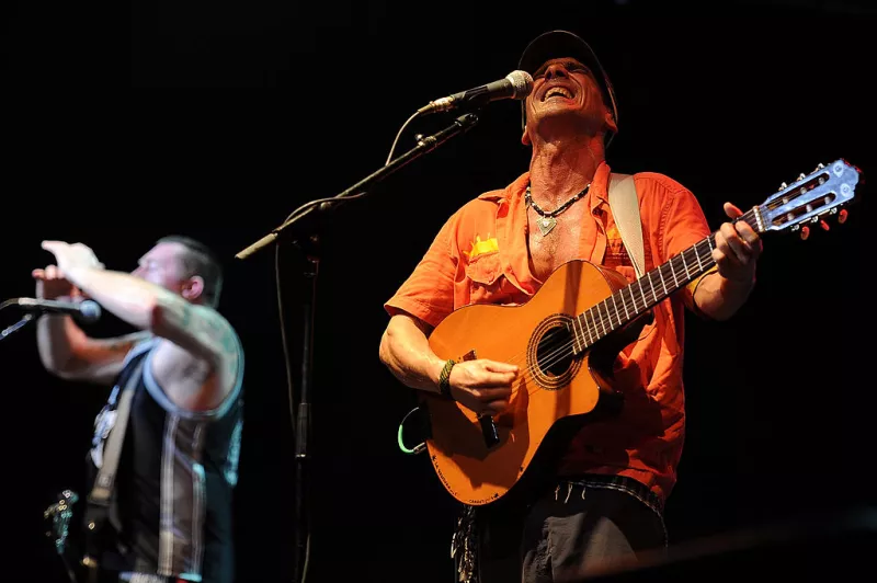 Foto de Manu Chao en 2013 cantando con su guitarra en Australia.