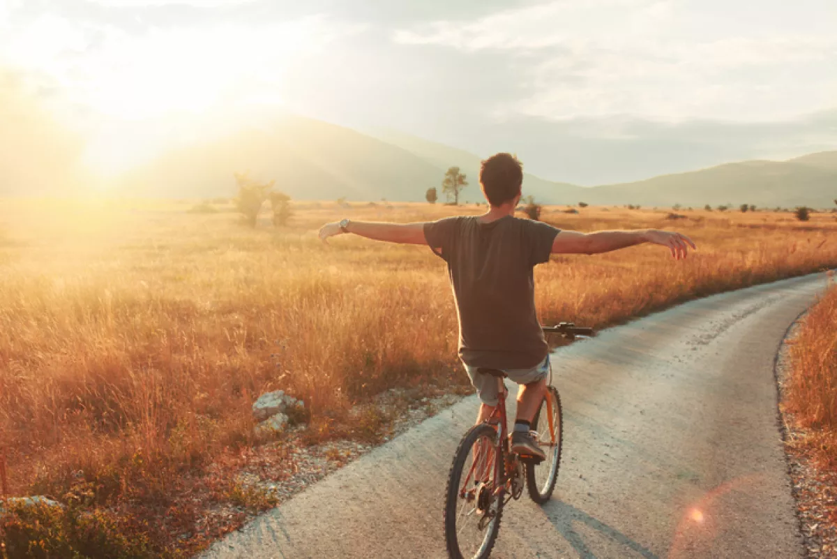 Hombre disfrutando atardecer saliendo a andar en bicicleta